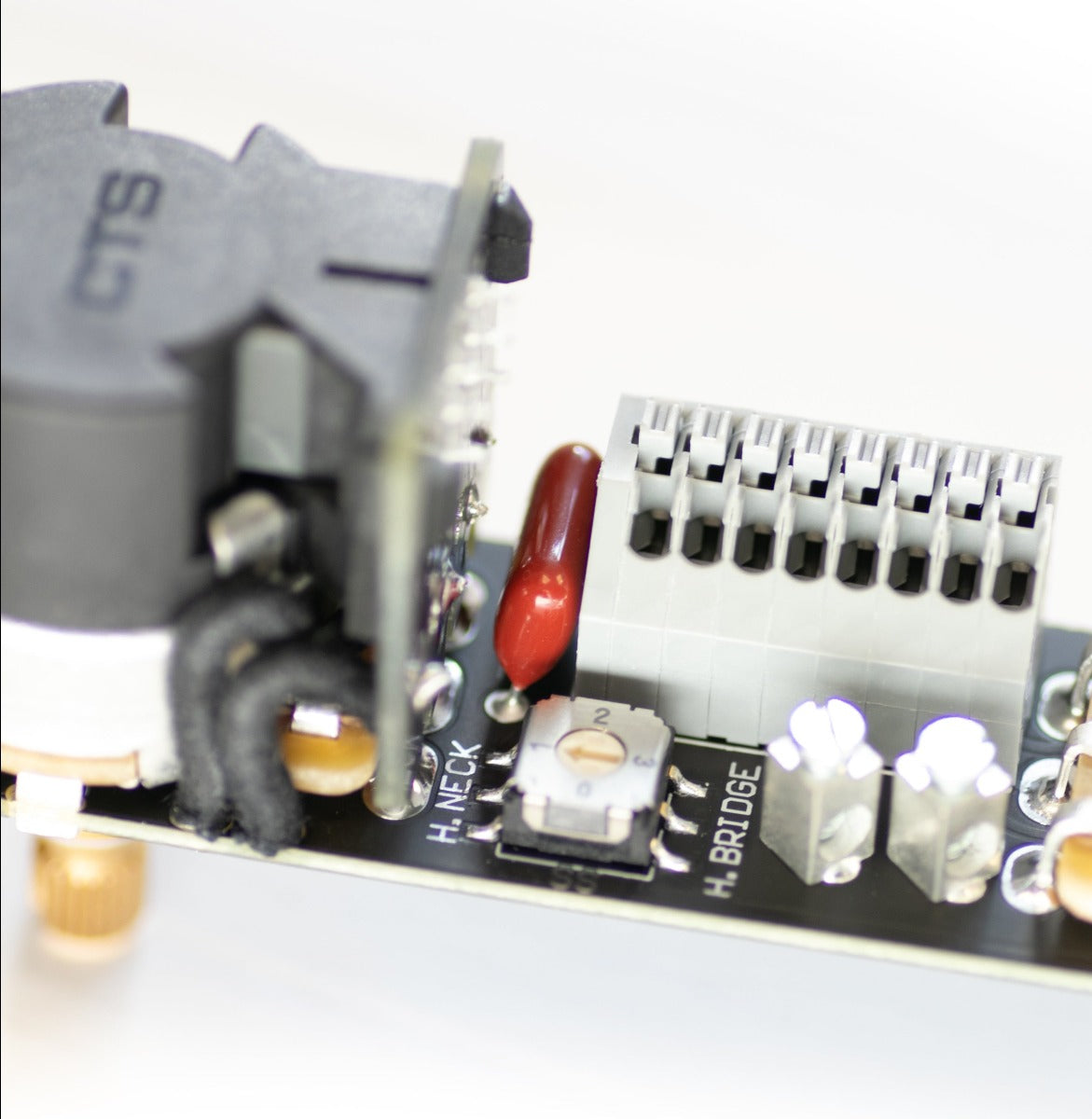 an ObsidianWire HH & HS  Custom Universal  Tele Wiring Harness is shown on a clear cut white background. The image is zoomed in in the small components of the harness.