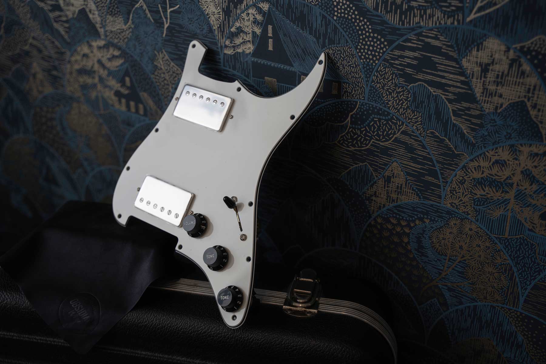 Guitar pickguard on a textured surface